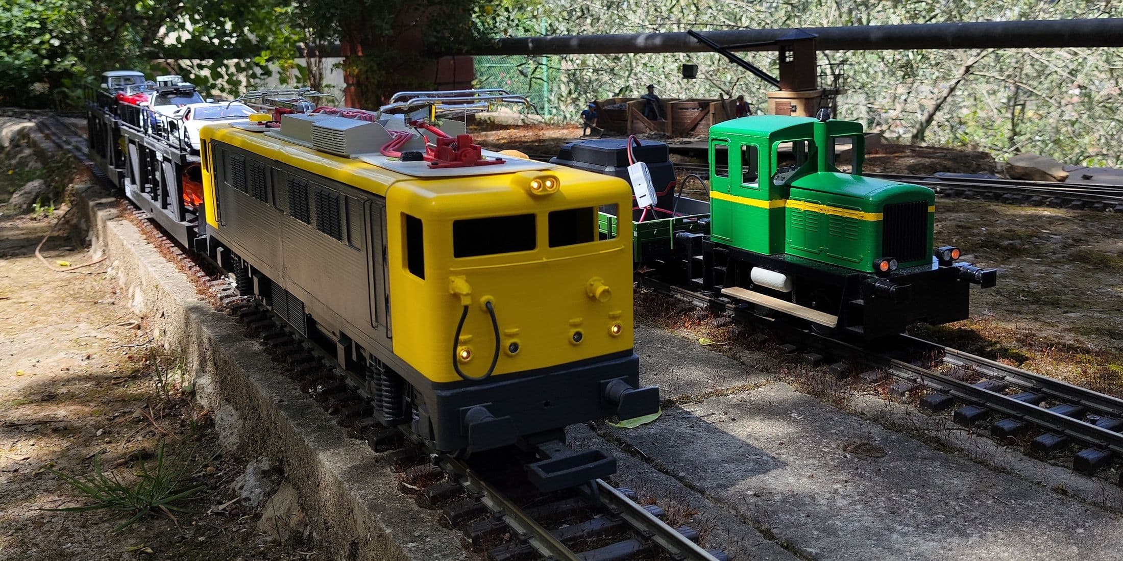 Locomotoras amarilla y verde con Decoder TruRail en un circuito de jardín